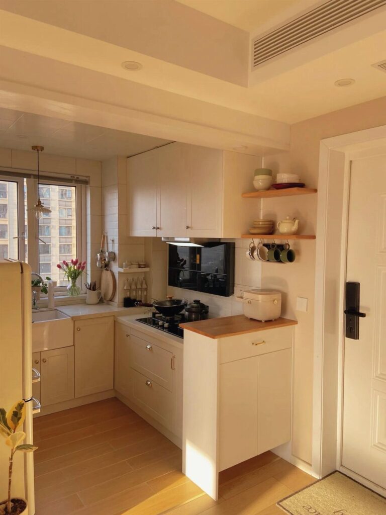Small white kitchen featuring light wood open shelving with bowls and dishes.