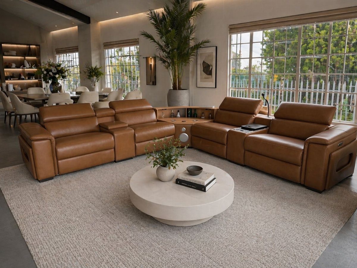 Caramel leather sectional sofa in a bright modern living room with white coffee table.