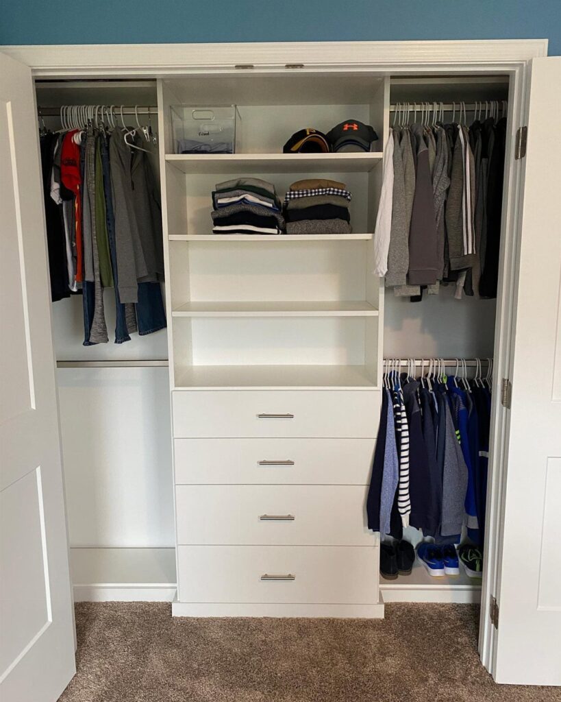 White reach-in closet with double-hang rods on the right and central shelving drawers.